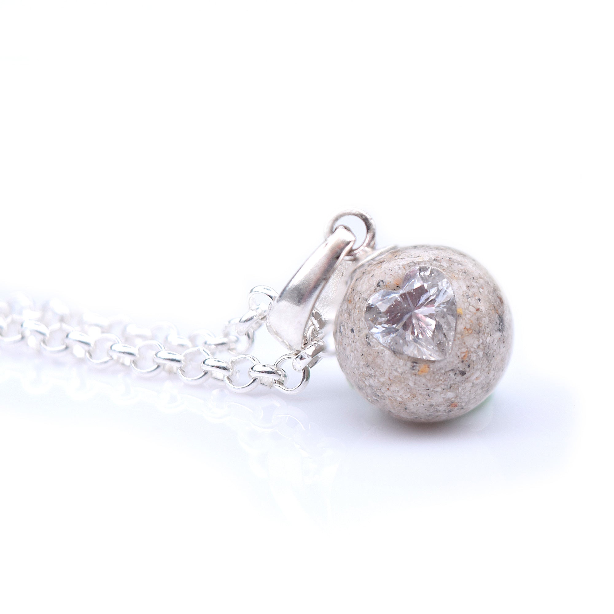 Pendentif boule de poussière de cendre + zircon coeur